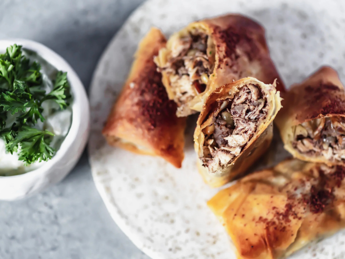 A modern adaptation of the traditional Palestinian musakhan, crispy musakhan rolls with yogurt dip