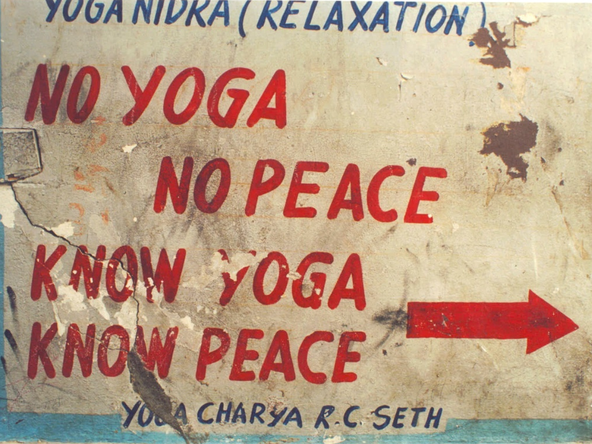 Photo taken by unknown photographer of a sign promoting yoga nidra (relaxation meditation) in India that says “No yoga, no peace. Know yoga, Know peace.