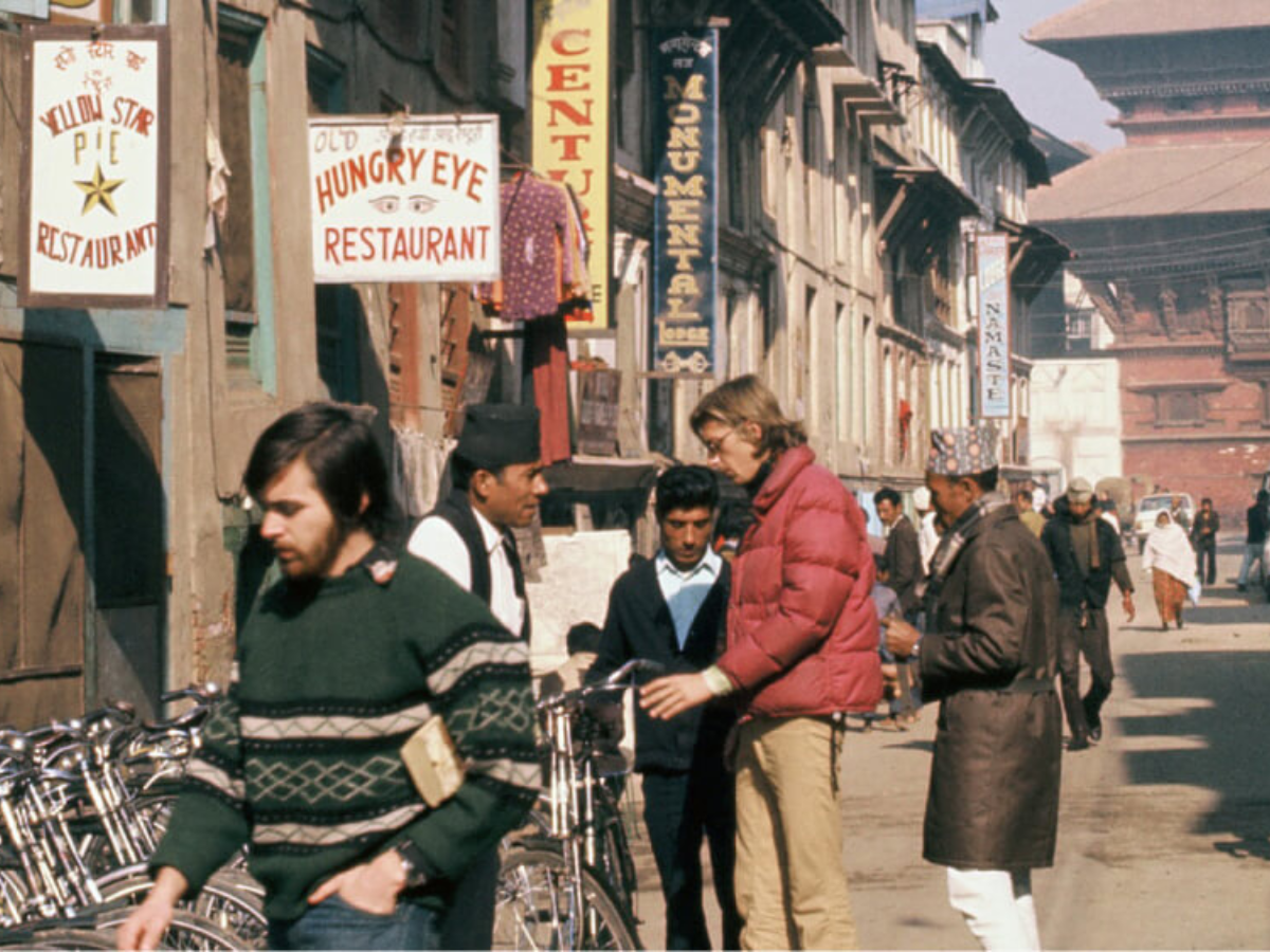 intage photo of Western travelers engaging with the locals of Nepal on the streets of Kathmandu