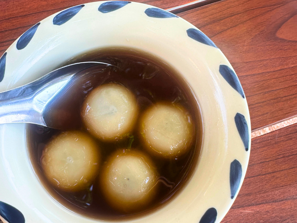 Decadent Thai-Chinese dessert Bua Loy Nam Khing, black sesame dumplings served in ginger tea