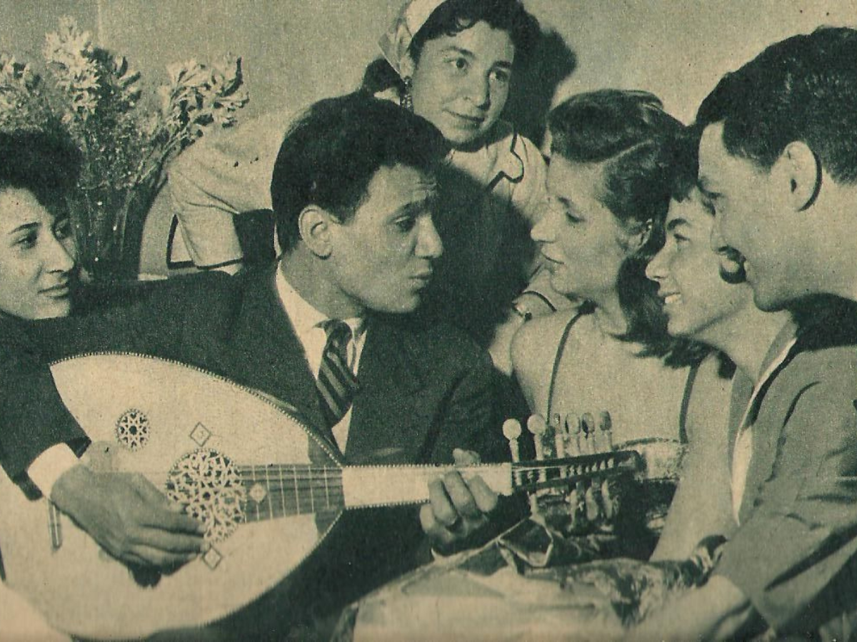 Iconic Egyptian tarab singer (mutrib) Abdel Halim Hafez photographed playing the oud instrument while surrounded by fans