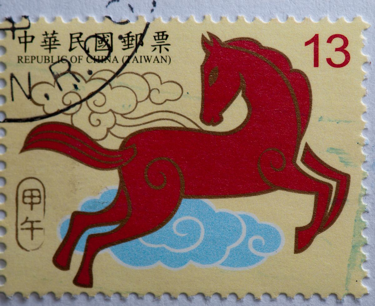 A post stamp depicting a red or crimson Fire Horse in reference to the Chinese Lunar New Year
