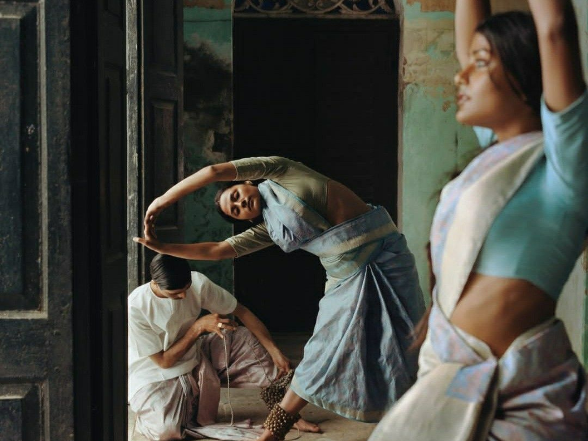 A group of South Asian yoga practitioners dressed in traditional attire and performing asanas