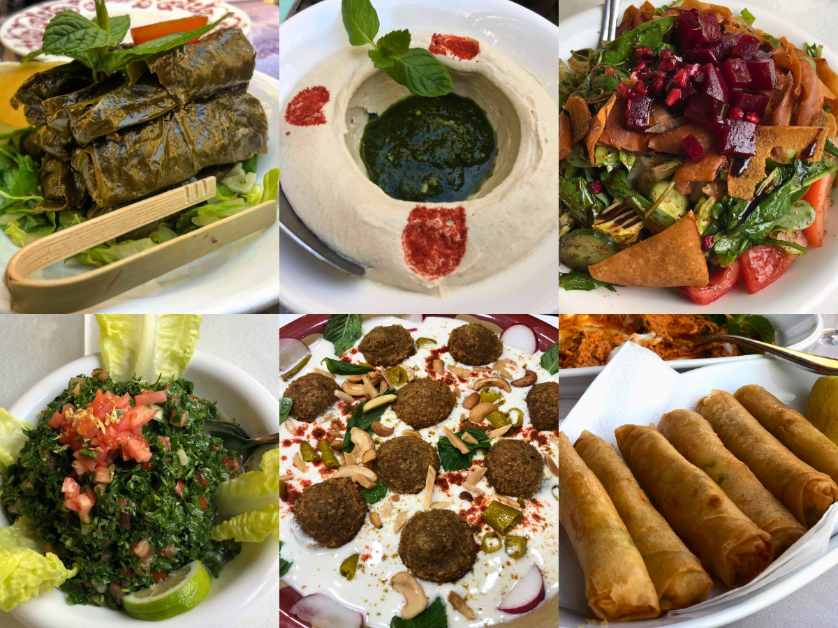 A range of Levantine mezze dishes such as stuffed vine leaves, tabbouleh, hummus with pesto, fried cheese rolls, and fattoush salad